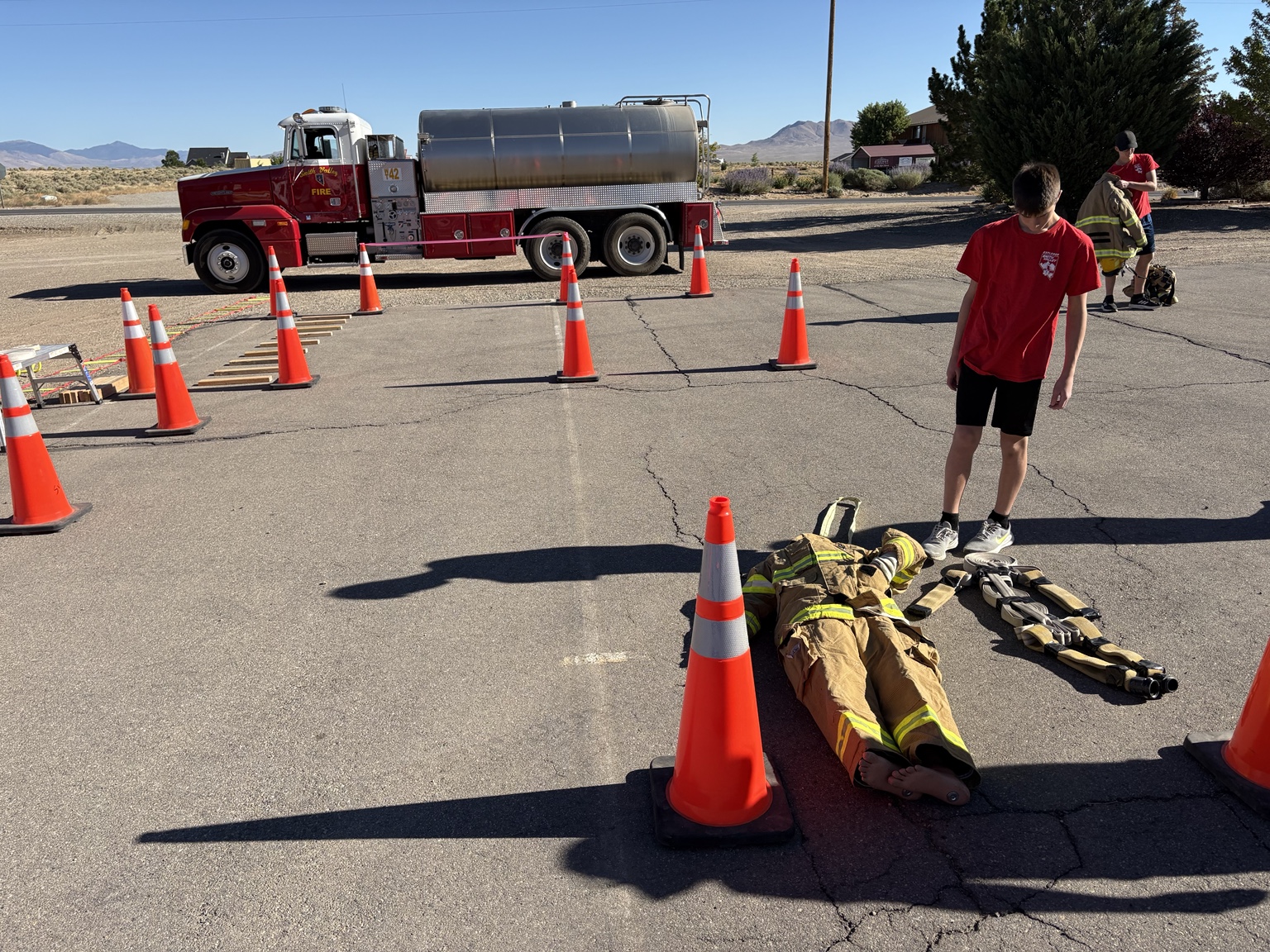 A Little Rascal Camp participant navigating a firefighter obstacle course beside SVFPD apparatus